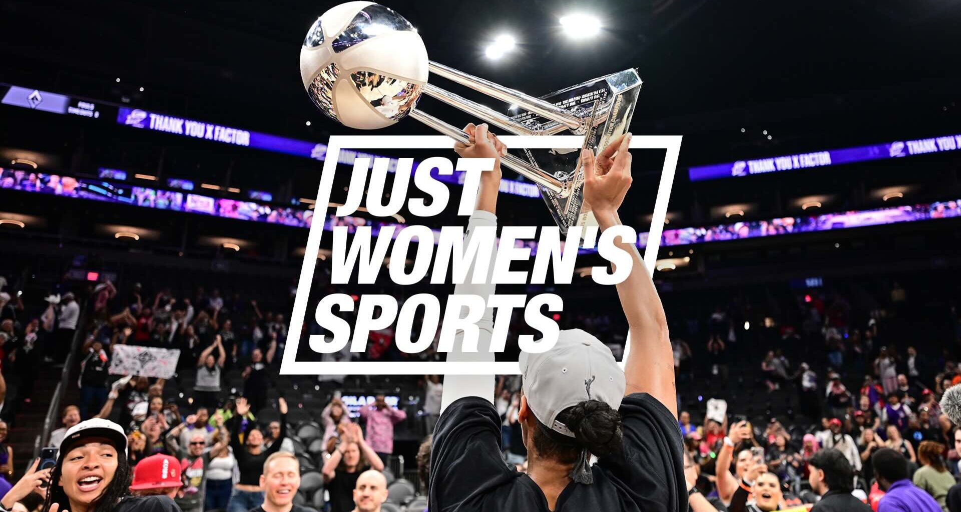 A'ja Wilson holds up the WNBA Championship trophy in front of a crowded stadium.