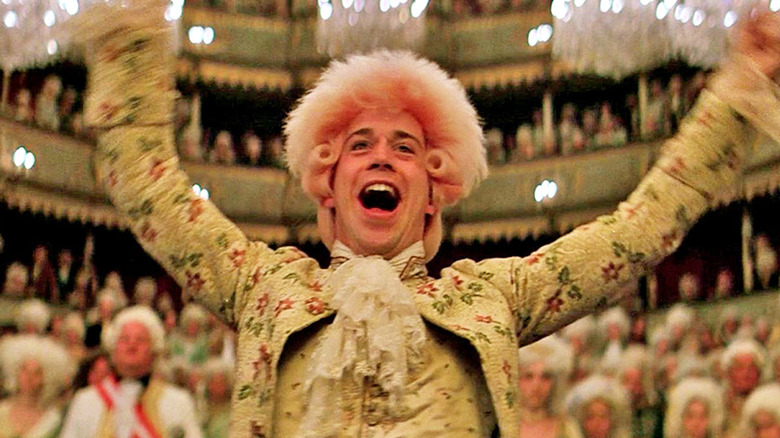 Tom Hulce as Wolfgang Amadeus Mozart, smiling and conducting in Amadeus