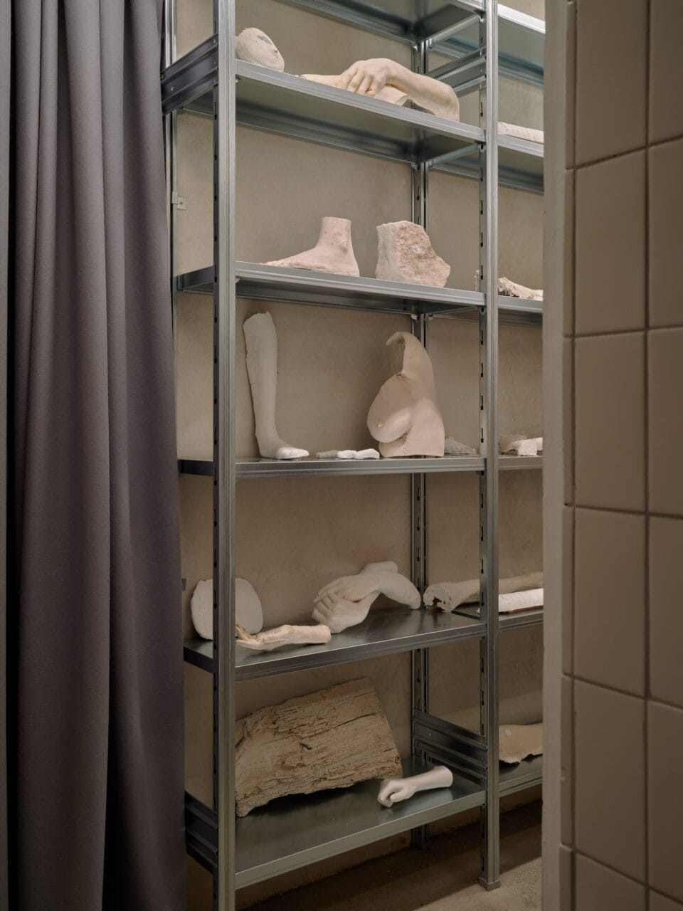 An art installation by Clementine Keith-Roach and Christopher Page of plaster body parts on a metal shelf