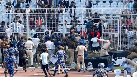 Reuters Crowds storm fences surrounding a football pitch in India. 
