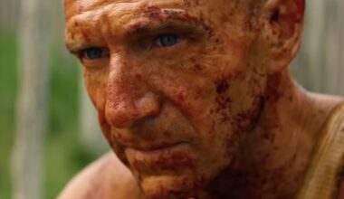 aging bald man covered in grime looking contemplative.