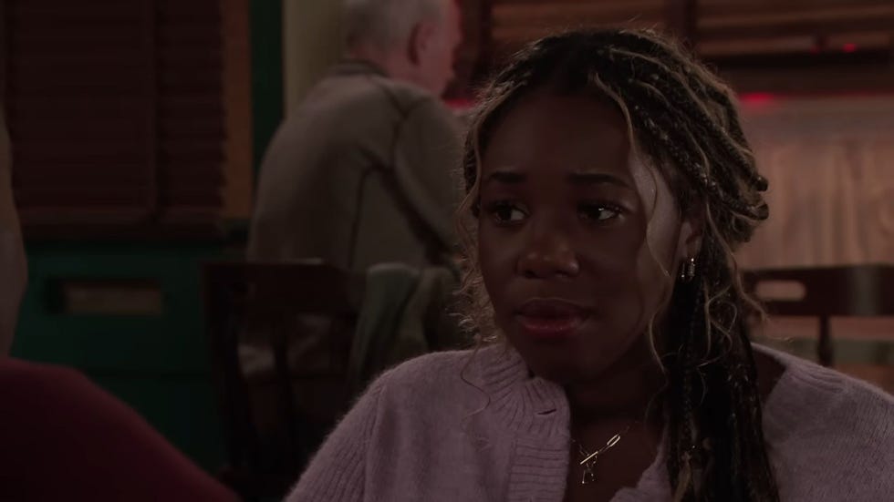 coronation street dee dee bailey in the cafe looking morose, wearing a light purple cardigan