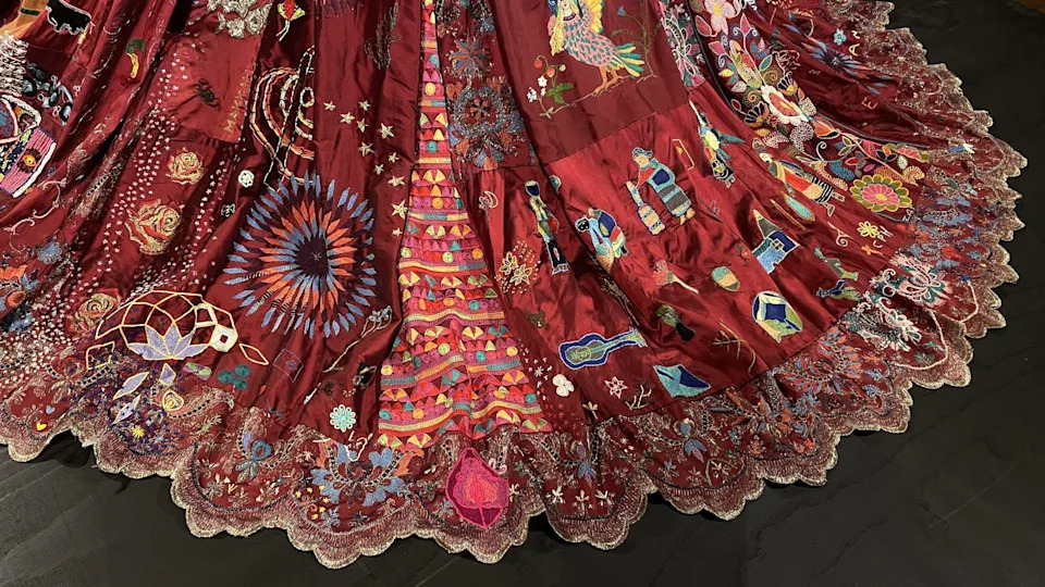 The hem of the dress is highly decorative with sequined lace and multicoloured embroidery. 