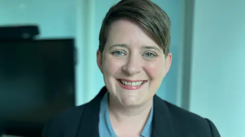 Minister for Equalities Olivia Bailey smiling at the camera.