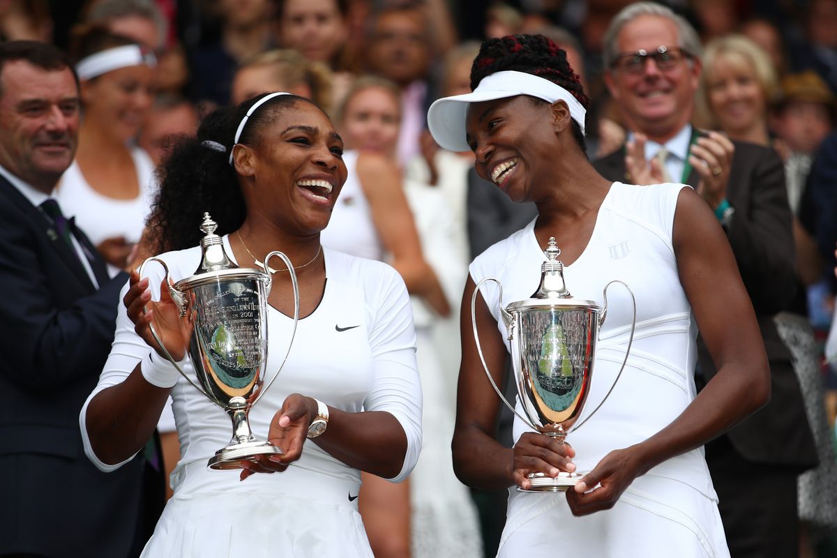 Venus and Serena hold their trophies after winning the Ladies Doubles Final at Wimbledon