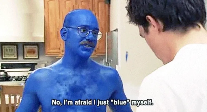 Man painted entirely blue talking to another person in a kitchen, saying, "No, I'm afraid I just 'blue' myself."