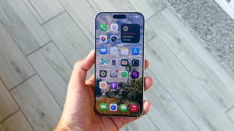 Hand holding iPhone 17 Pro Max with home screen icons