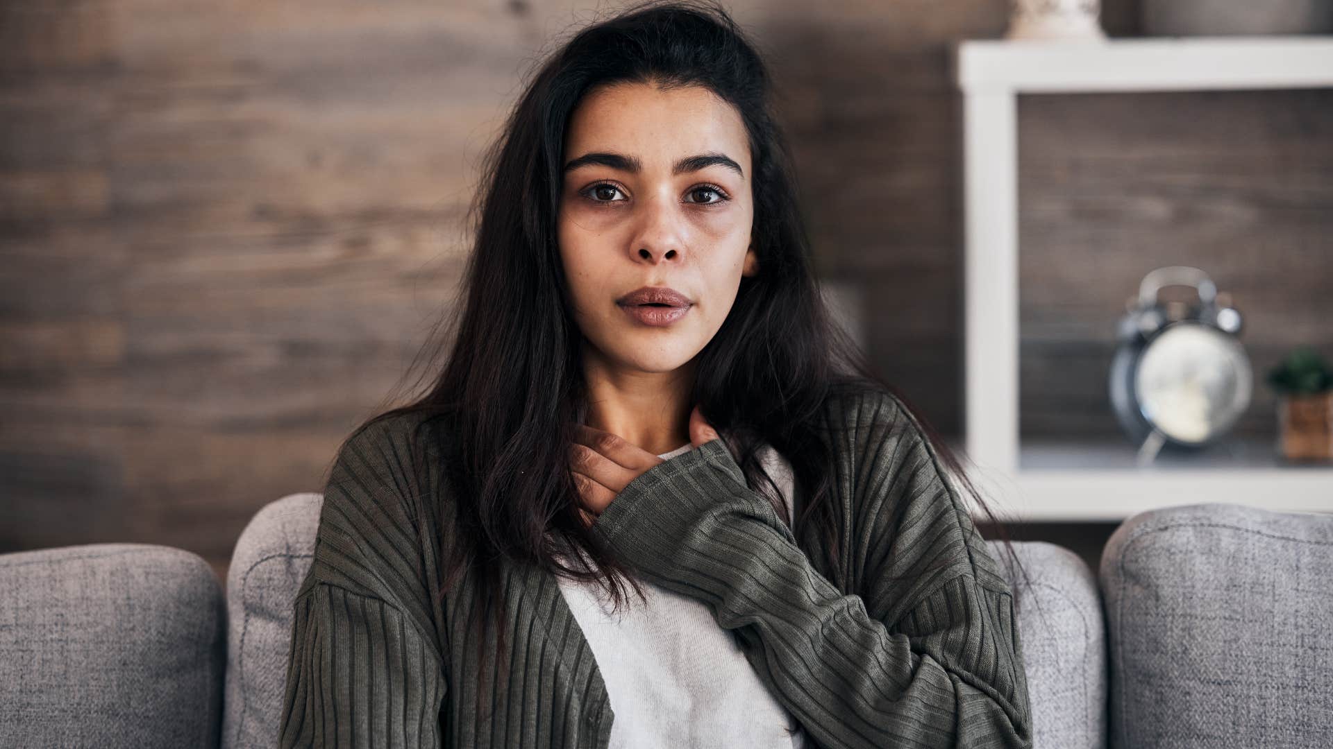 woman holding chest feeling anxious for no reason