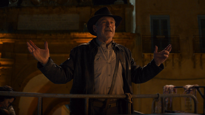 Harrison Ford as Indiana Jones with his hands up in Indiana Jones and the Dial of Destiny