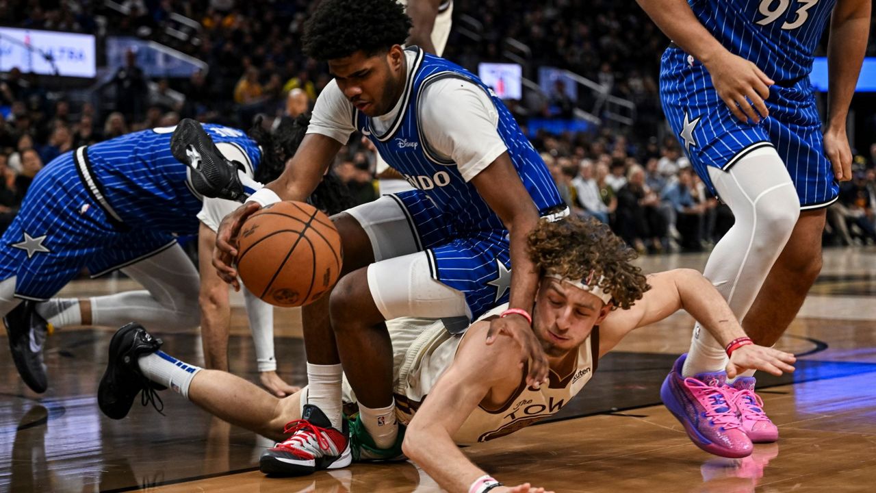 Magic guard Jase Richardson lands on top of Warriors guard Brandin Podziemski in a scramble for a loose ball during the second half on Monday, Dec. 22, 2025, in San Francisco (AP Photo/Justine Willard)