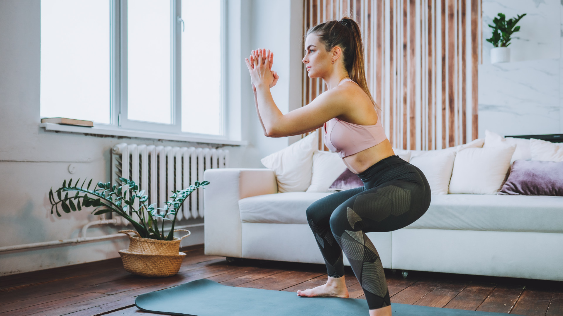 A woman performing a deep bodyweight squat