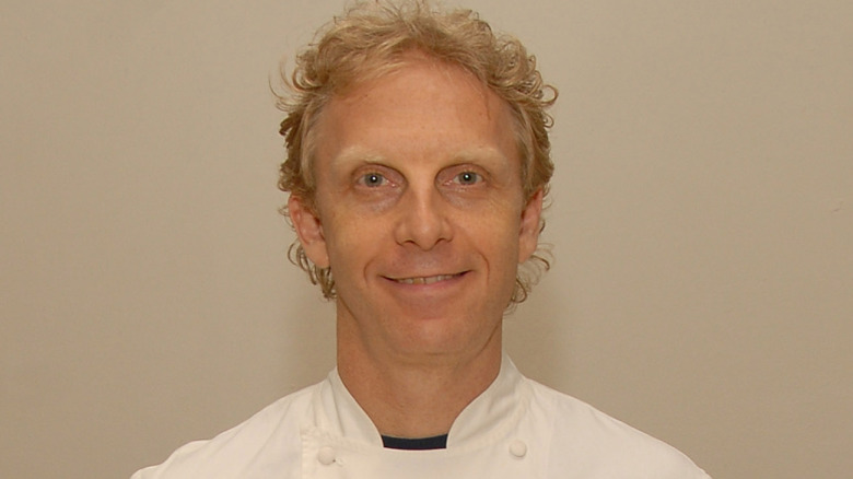 Matthew Tivy smiling while wearing white chef coat