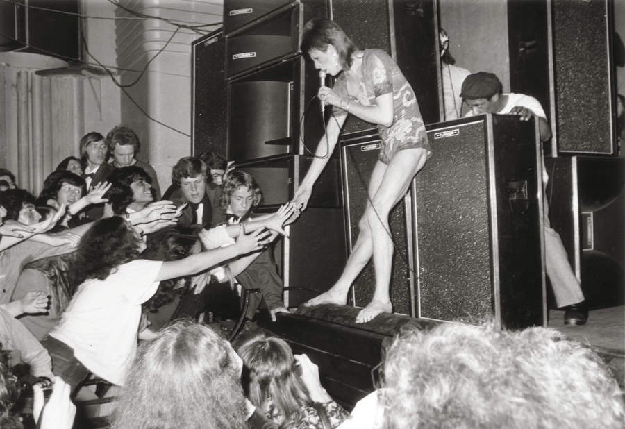 Adoring fans reaching out to touch the hand of the English pop star, David Bowie, during the concert at the Hammersmith Odeon, where Bowie announced that he was retiring his alter-ego 'Ziggy Stardust