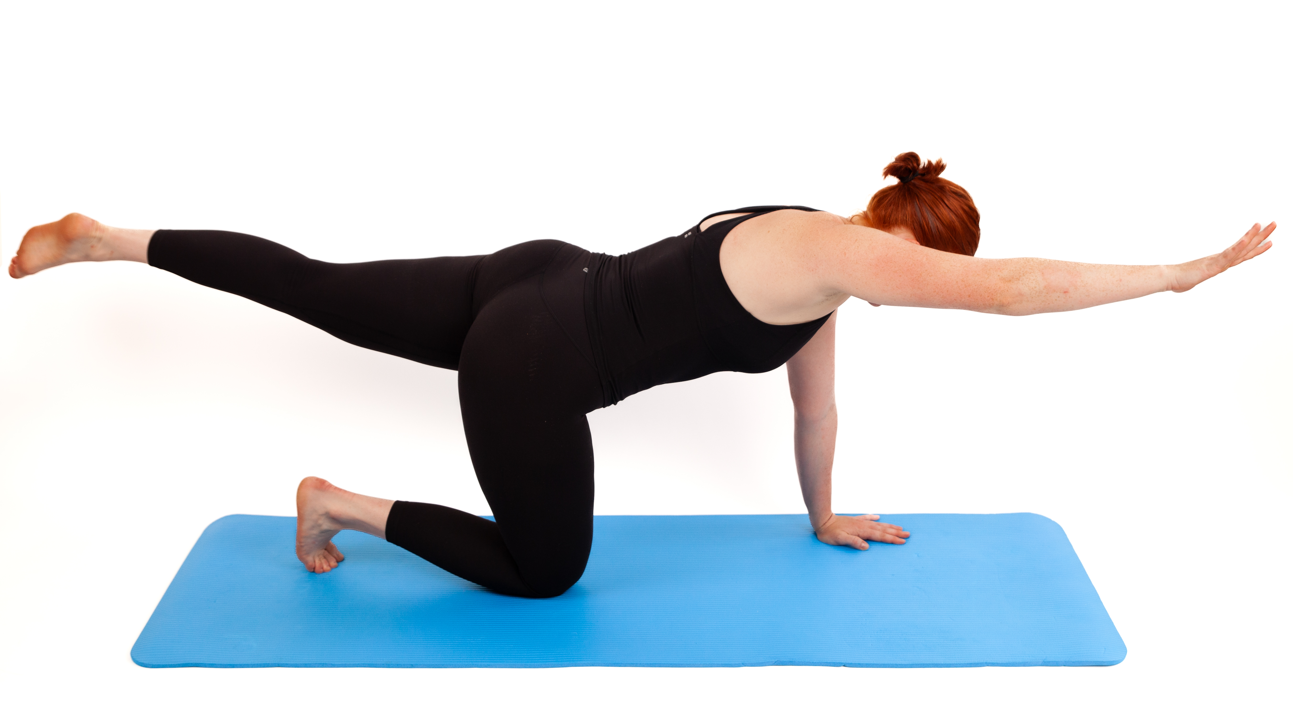 Woman demonstrates Pilates exercise on blue exercise mat against white background