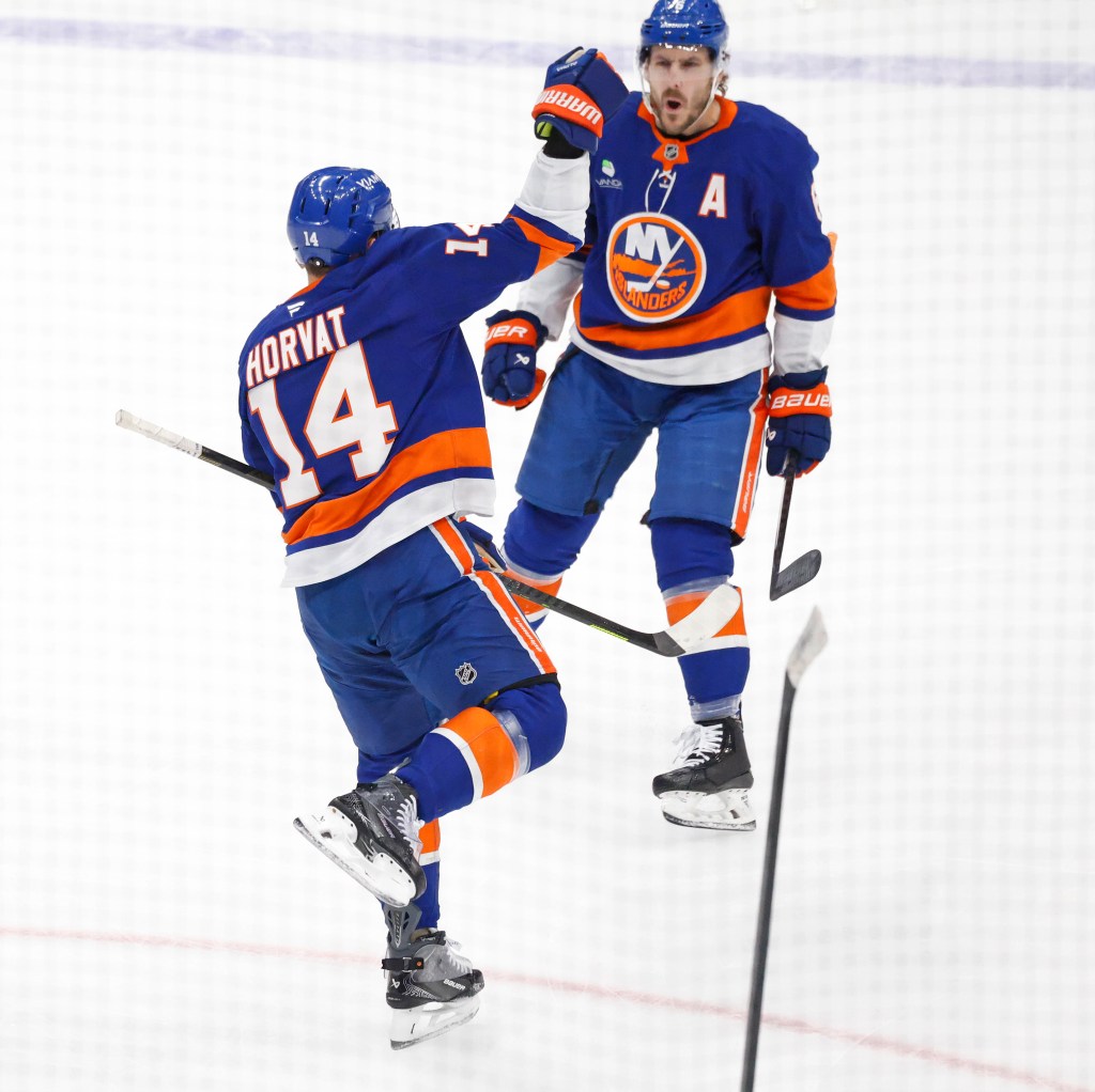 New York Islanders center Bo Horvat (14) celebrates a goal with a teammate.
