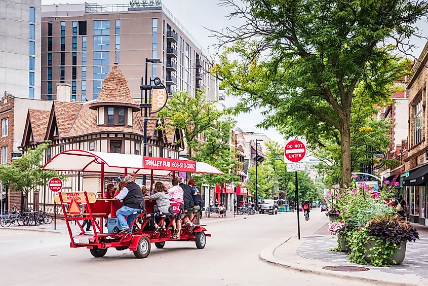 Tourists exploring State Street in Madison, Wisconsin, on a trolley.