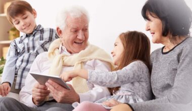 Happy grandchildren and grandparents using a tablet in living room