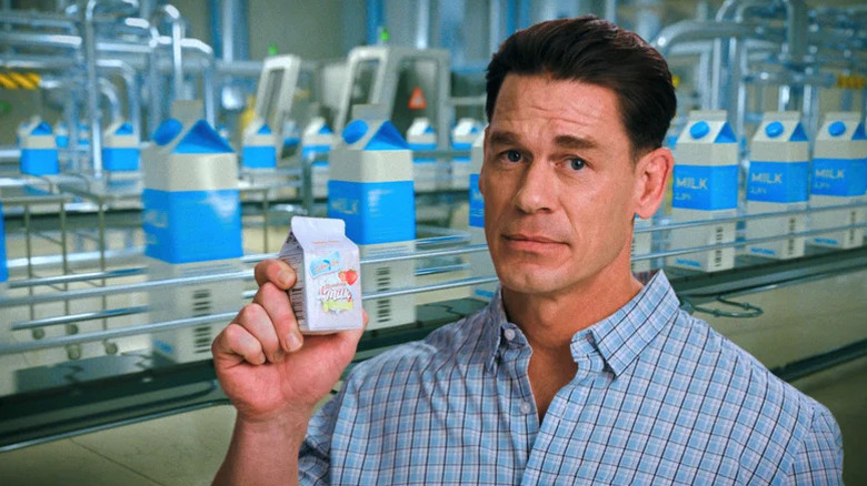 John Cena holding up a HDP carton on Pluribus