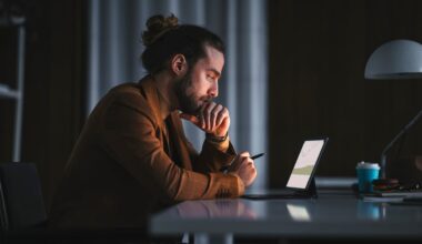 An investor looks at something on a tablet in a darkened office.