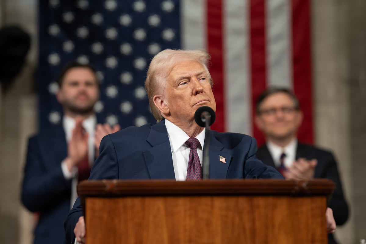 President Donald J. Trump stands at a podium with an American flag in the background.