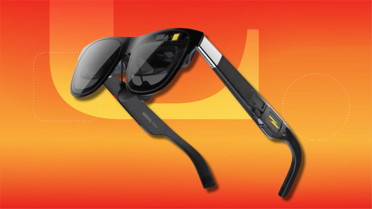 Xreal One AR glasses on orange-yellow CNET background.