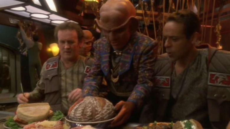 Quark (Armin Shimerman) places a loaf between Miles O'Brien (Colm Meaney) and Julian Bashir (Alexander Siddig) in Star Trek: Deep Space Nine