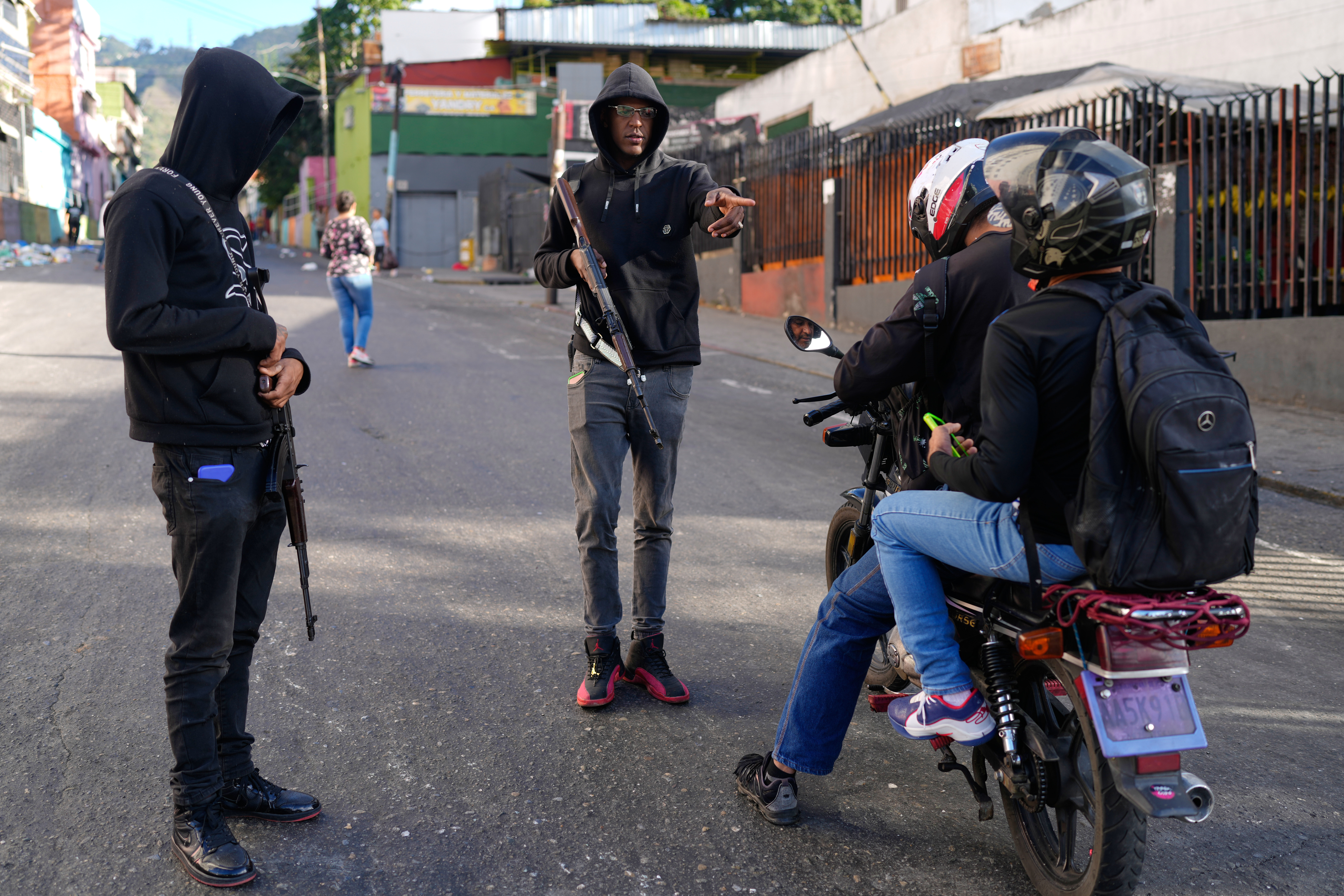 Pro-government armed civilians stop motorcyclists in Caracas, Venezuela.