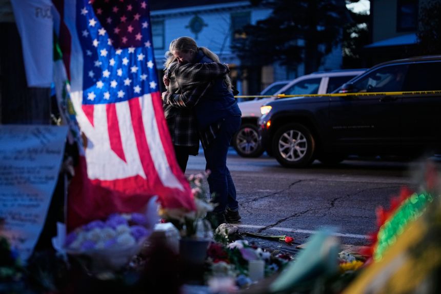Monica Travis on January 12 shares an embrace while visiting a makeshift memorial for Renee Good in Minneapolis.