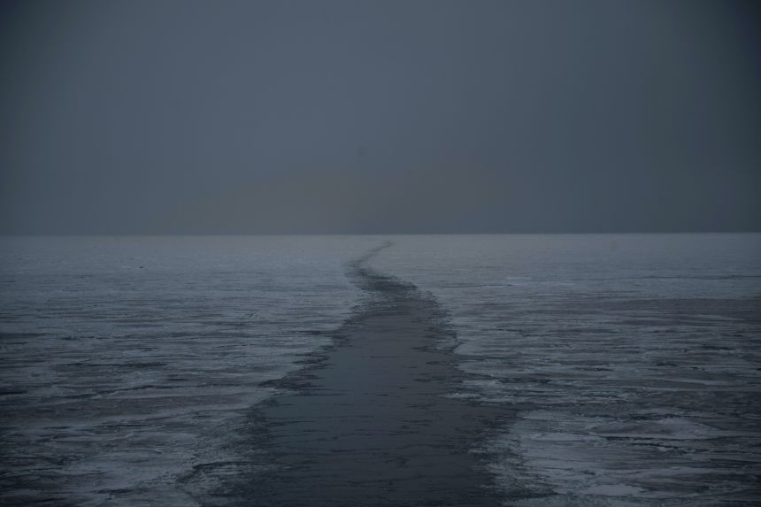 A scientific boat's wake is seen in sea ice in eastern Spitzbergen, in the Svalbard archipelago, on April 6, 2025.