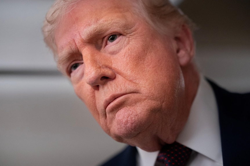 A close up photo of Donald Trump listening intently.