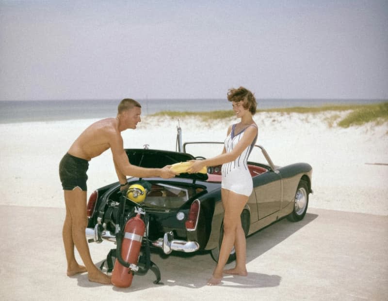 Couple with vintage car on Florida beach