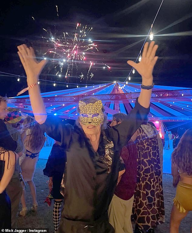 Mick Jagger, 82, puts on an animated display in animal mask as he rings in the New Year at outdoor party