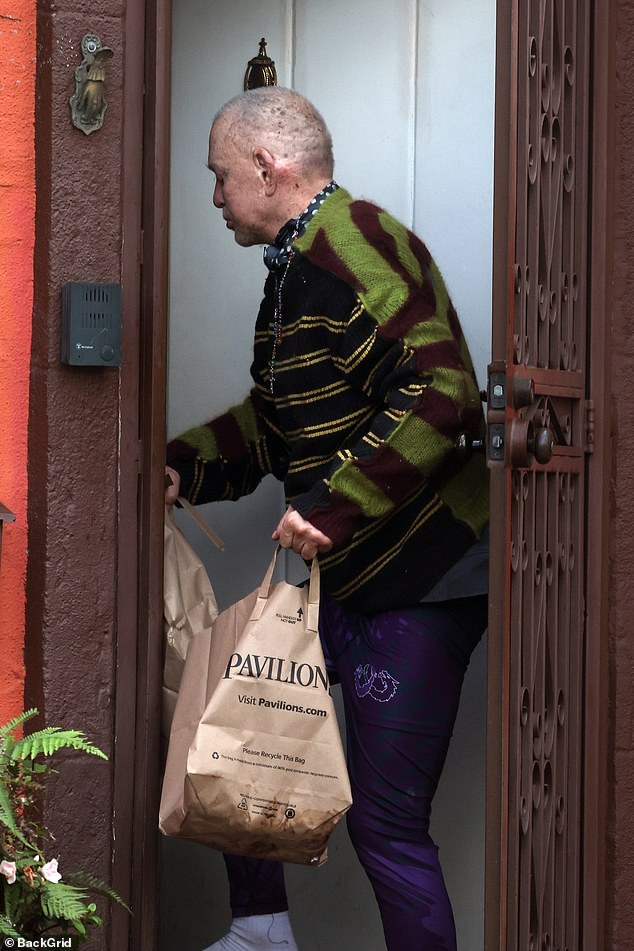 Wearing a striped sweater, rosary, and no shoes on, a frail Rourke looked somber during his rare public outing, amid continued turmoil in his personal life