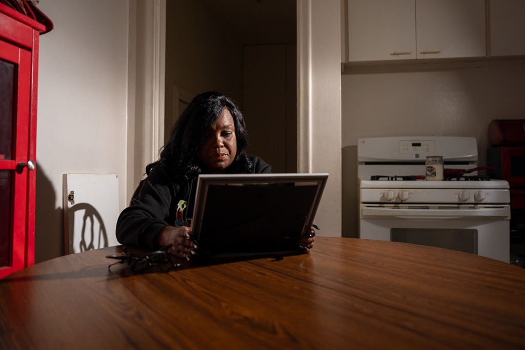 Shanica League, 52, looks at a photo of her late father, Morris Lee Wilson, inside her Detroit home