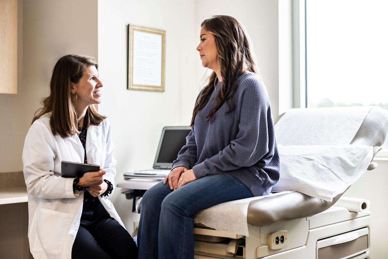 female doctor discussing treatment with female patient in exam room