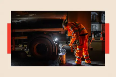 Getty Images Road workers laying Hot Rolled Asphalt during a night time road closure 