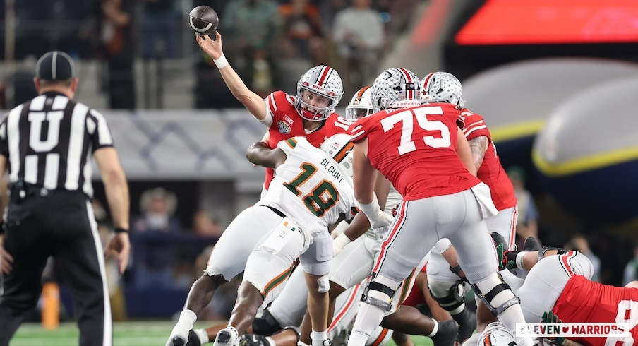 Julian Sayin getting hit as he throws by Miami’s Armondo Blount