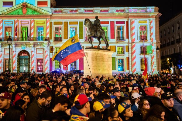 Venezuelans celebrate in Madrid, Saturday, Jan. 3, 2026, after U.S. President Donald Trump announced that President Nicolás Maduro had been captured and flown out of Venezuela. (AP Photo/Bernat Armangue)