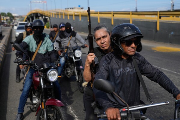 Pro-government armed civilians patrol in La Guaira, Venezuela, Saturday, Jan. 3, 2026, after U.S. President Donald Trump announced that President Nicolás Maduro had been captured and flown out of the country. (AP Photo/Matias Delacroix)
