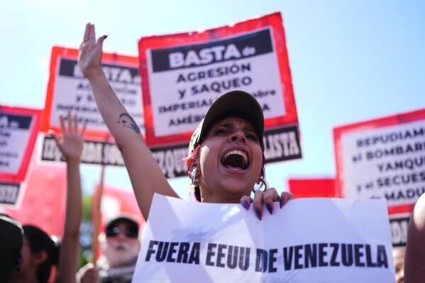 A demonstrator holds a banner with a message that reads in Spanish: "Out of Venezuela, U.S." during a protest outside the U.S embassy after President Donald Trump announced that Venezuelan President Nicolas Maduro had been captured, in Buenos Aires, Argentina, Saturday, Jan. 3, 2026. (AP Photo/Natacha Pisarenko)