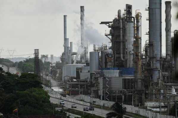 Vehicles drive past the El Palito refinery in Puerto Cabello, Venezuela, Sunday, Dec. 21, 2025. (AP Photo/Matias Delacroix)