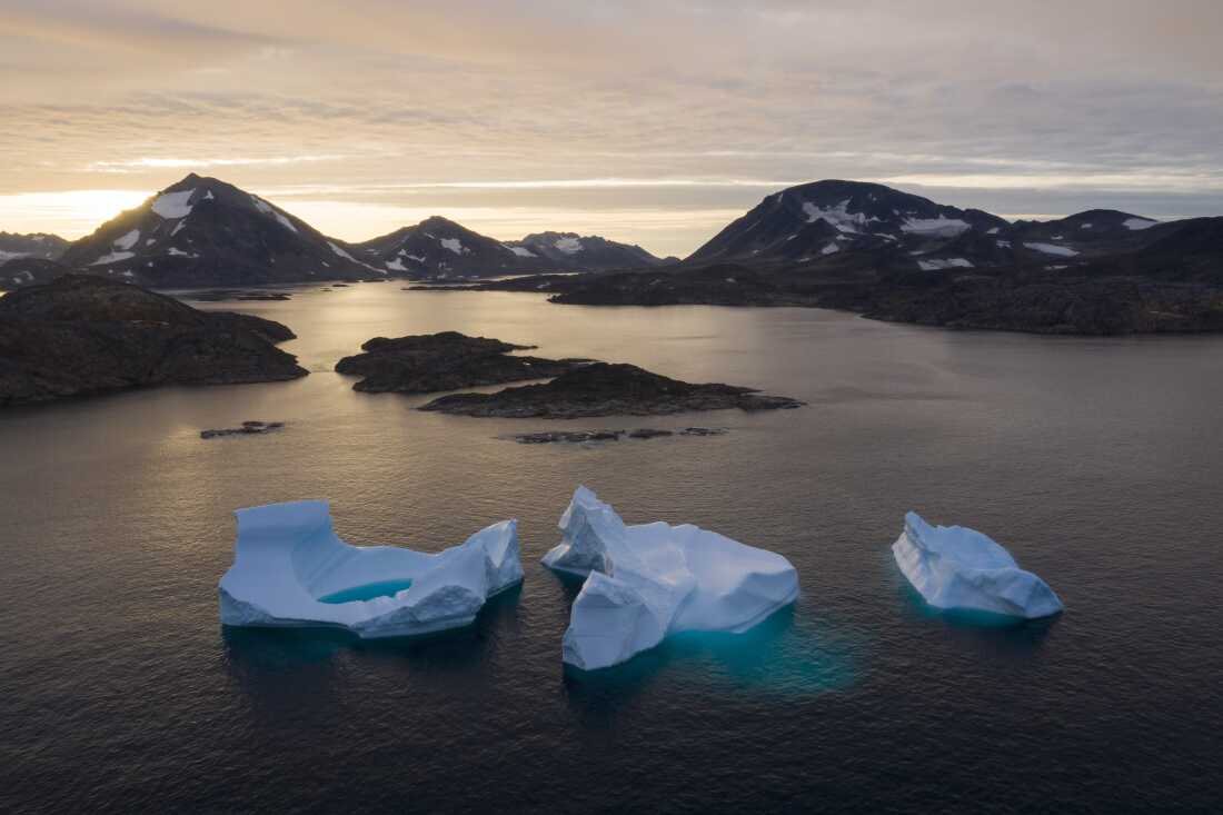 FILE - In this Aug. 16, 2019, photo, large Icebergs float away as the sun rises near Kulusuk, Greenland.