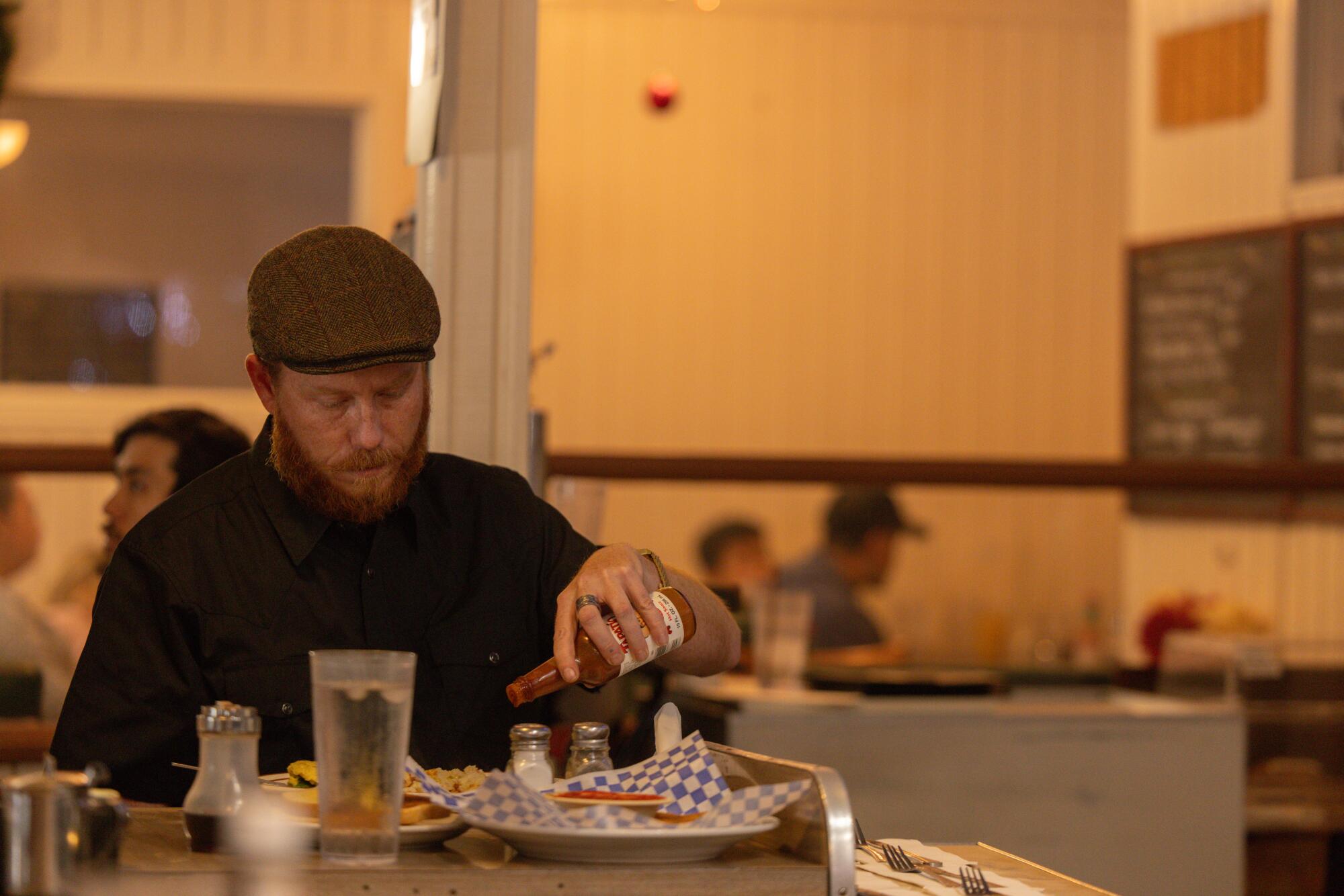 Jackson Hahn dresses his food with hot sauces at the Original Saugus Cafe.
