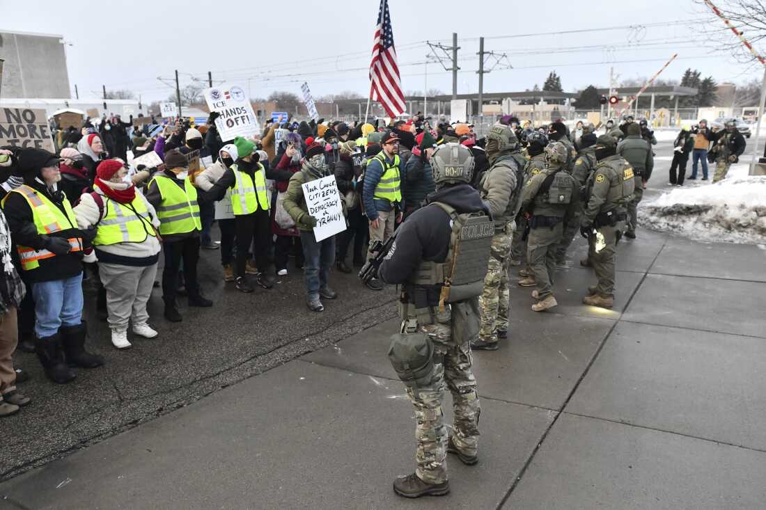 Federal agents stand watch as protestors gather outside the Bishop Henry Whipple Federal Building in Saint Paul, Minnesota, on January 8, 2026. A US Immigration and Customs Enforcement (ICE) agent shot and killed an American woman on the streets of Minneapolis January 7, leading to huge protests and outrage from local leaders who rejected White House claims she was a domestic terrorist. The woman, identified in local media as 37-year-old Renee Nicole Good, was hit at point blank range as she apparently tried to drive away from agents who were crowding around her car, which they said was blocking their way.
