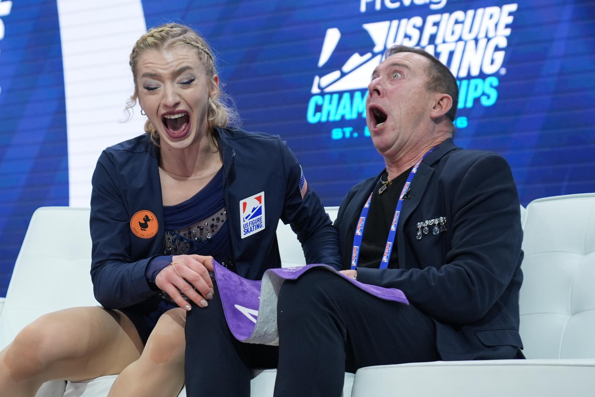 Amber Glenn and her coach, Damon Allen, react to her winning scores Friday.