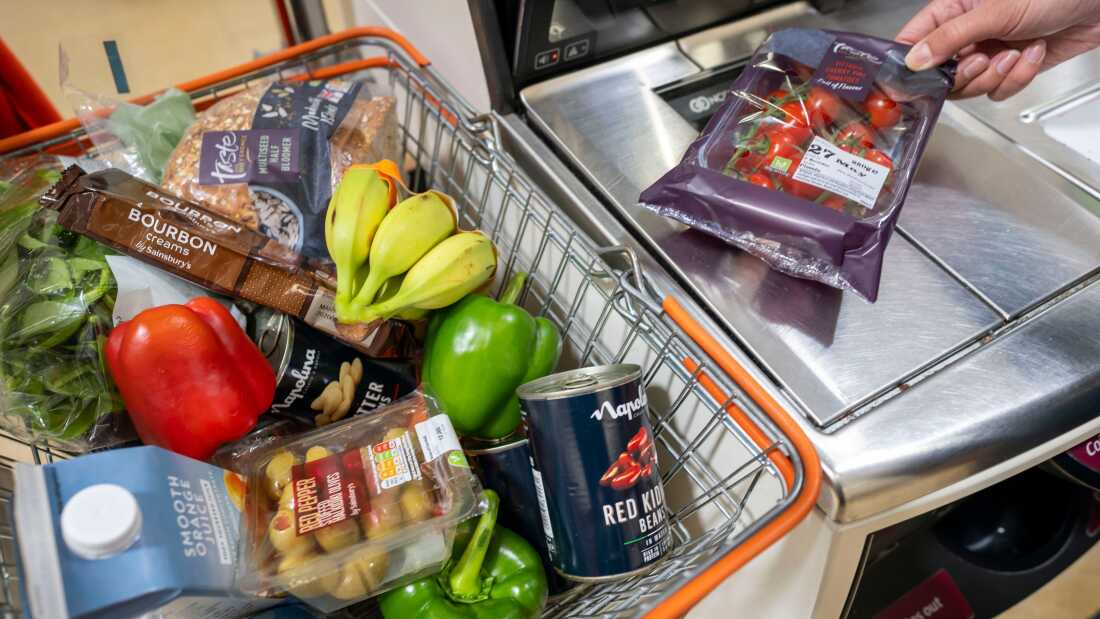 A woman scans groceries at a self service checkout in a supermarket.