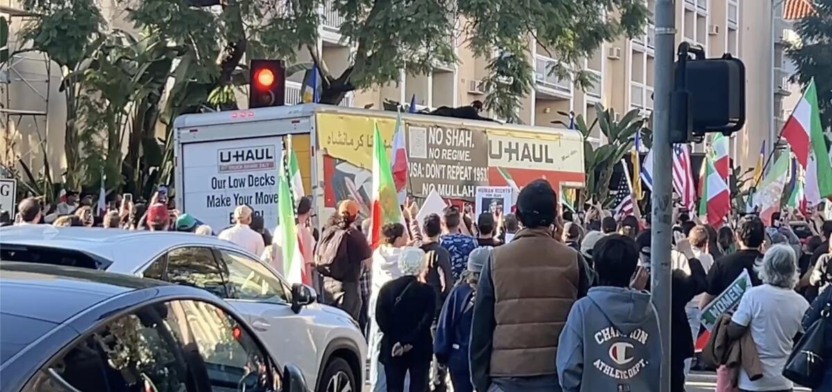 A U-Haul truck is seen amid a crowd, some carrying green, white and red flags