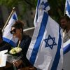 People hold signs and Israeli national flags in a sign of support outside the Capital Jewish Museum following a shooting that left two people dead, in Washington, DC, on May 22, 2025.