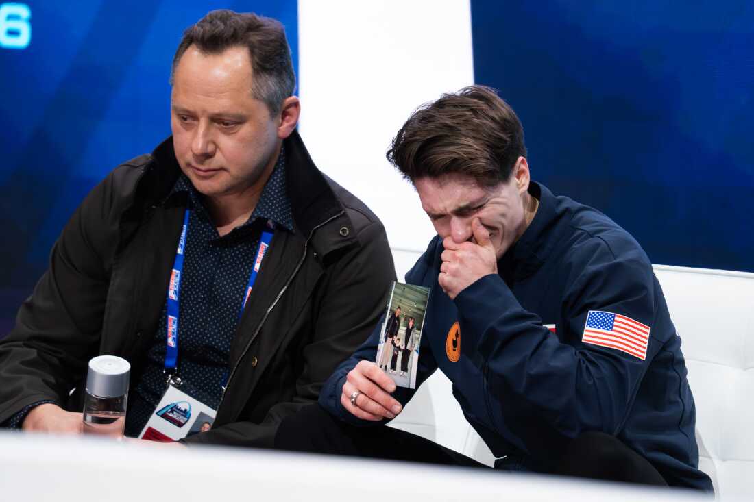 Maxim Naumov holds a photo of his parents while he waits for his scores after competing at nationals in St. Louis in January.