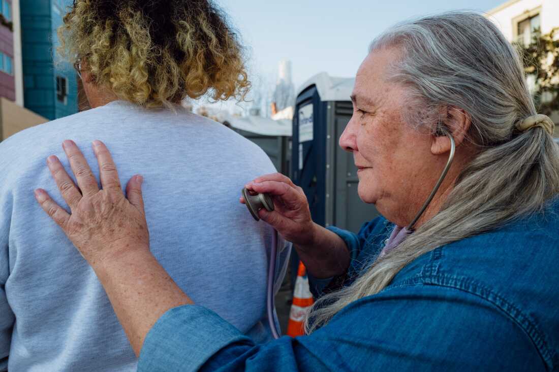 Dr. Mary Marfisee conducts a brief breathing check on a woman on Los Angeles' Skid Row on December 15, 2025.